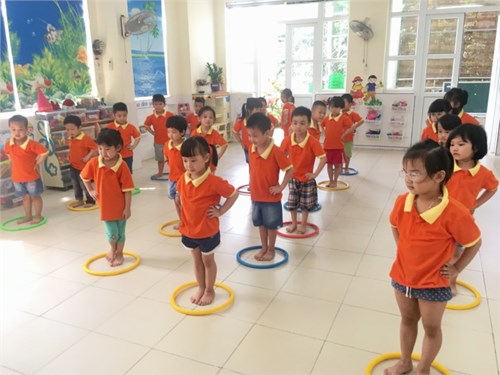 Các bé lớp mẫu giáo nhỡ B2 hứng thú tập các động tác thể dục sáng với vòng
